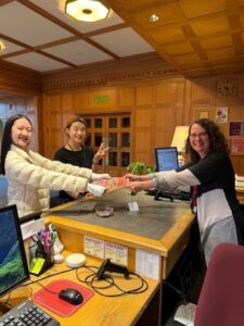 two female students handing in their scavenger hunt sheet to the archivist at the library's main desk